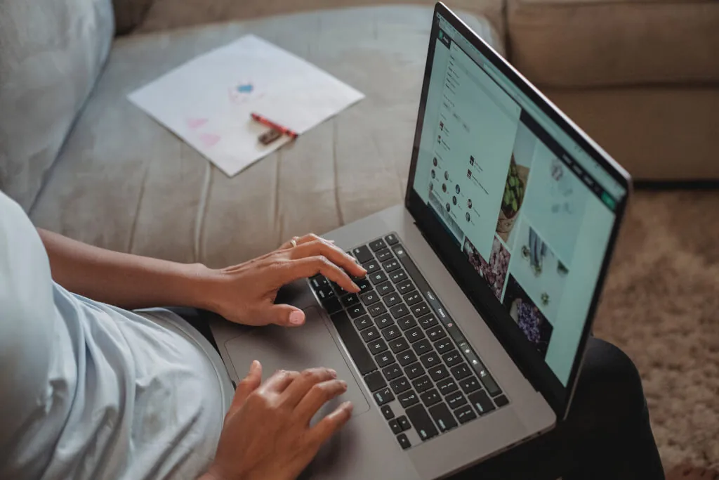 Woman working on laptop with images on screen